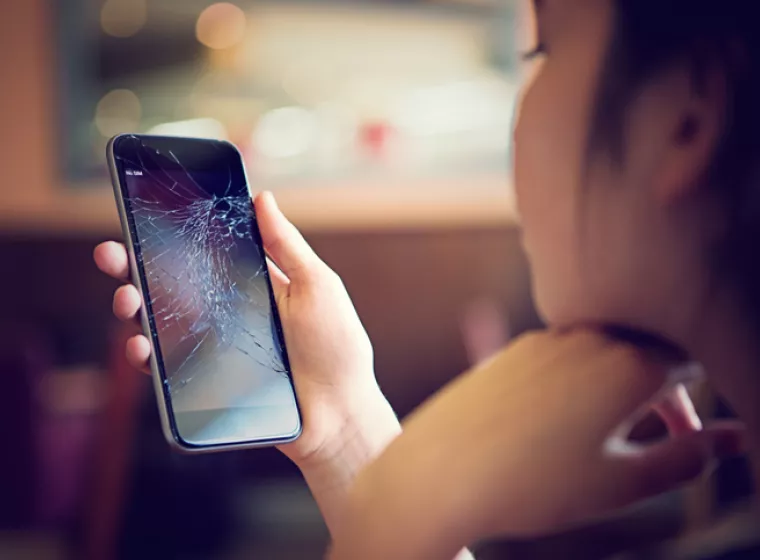 Girl looking at broken phone screen